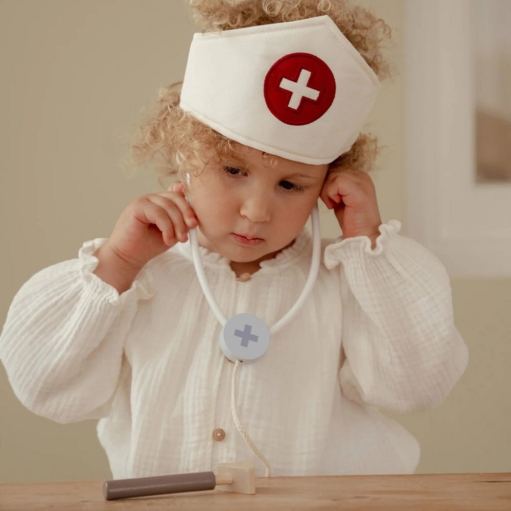 Η υφασμάτινη τσάντα περιλαμβάνει θερμόμετρο, σύριγγα, επιδέσμους, στηθοσκόπιο, πιεσόμετρο και καπέλο γιατρού.